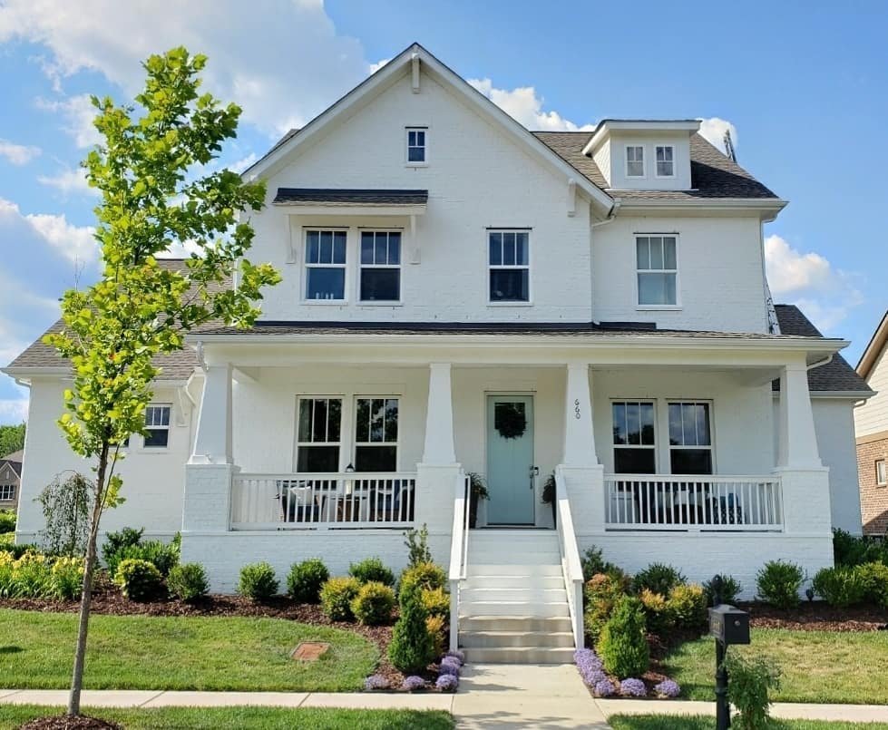 Brick home painted white with a light blue door.