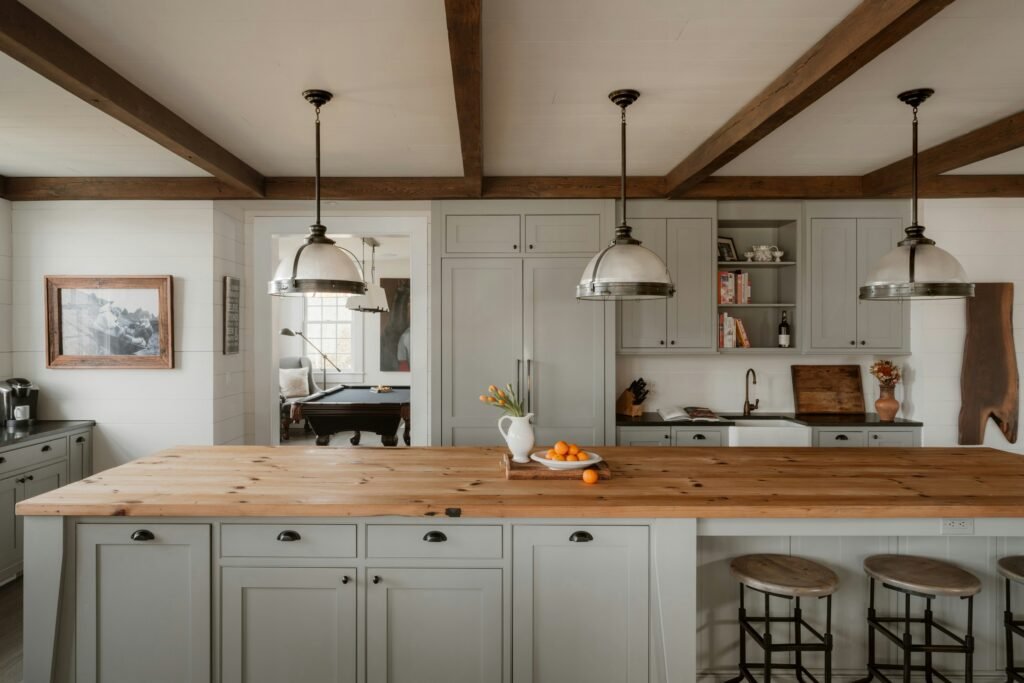 Modern farmhouse kitchen with warm neutral cabinets painted in soft greige and natural wood island top, featuring timeless cabinet color trends for 2026 in kitchen design.
