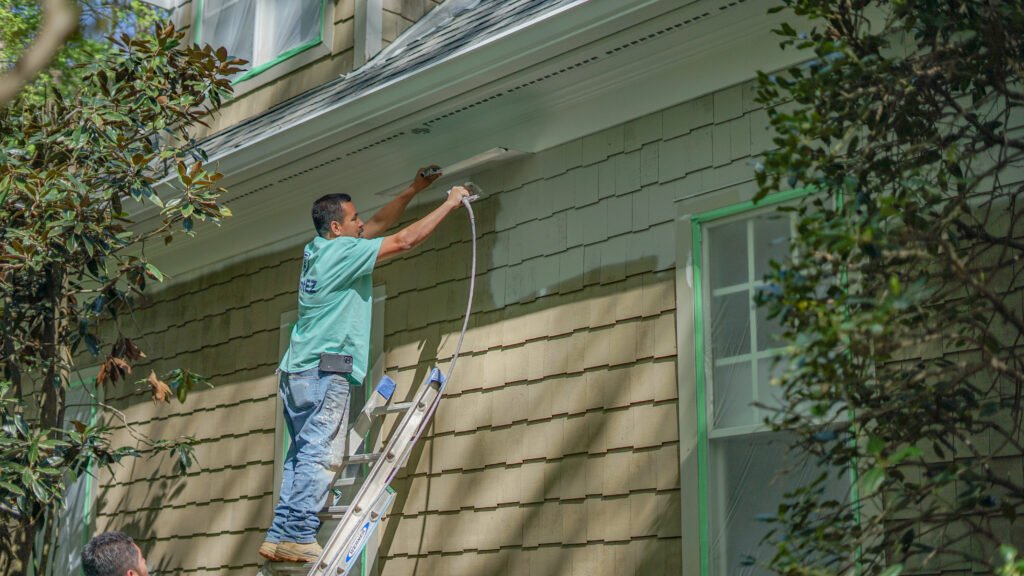 Professional Paint EZ painter applying exterior paint to a home, highlighting proper prep work and long-lasting results for increased resale value