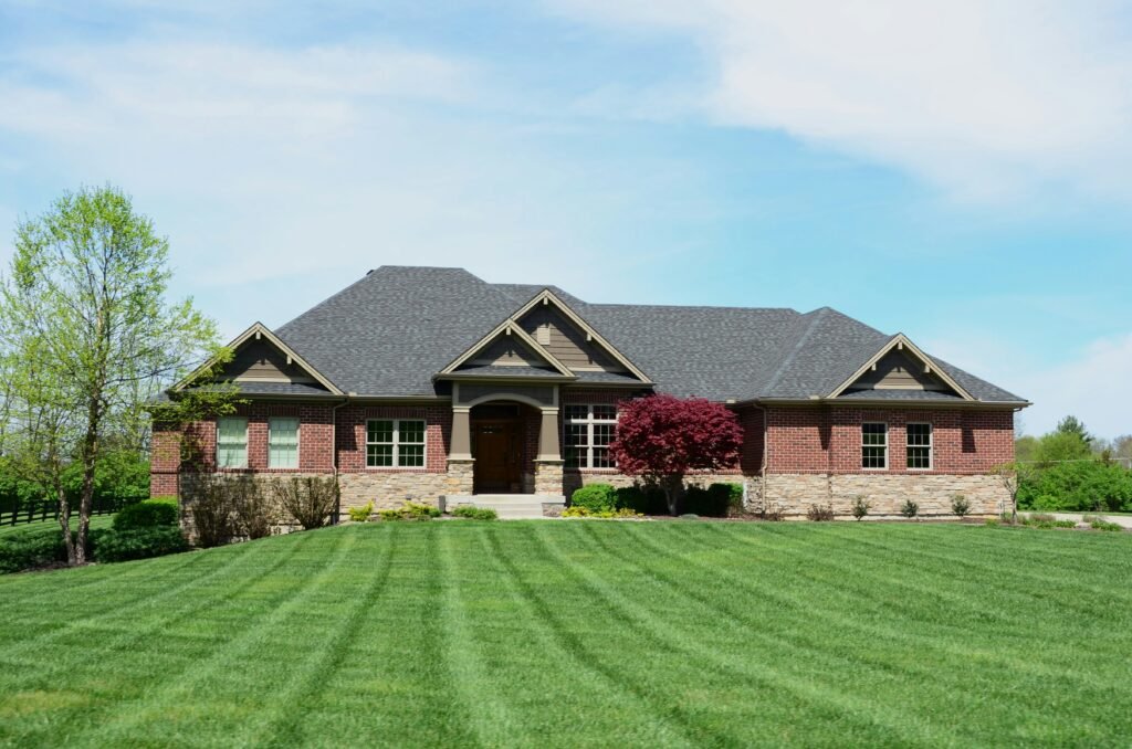 Brick and stone home with brown roofing and coordinated neutral exterior colors