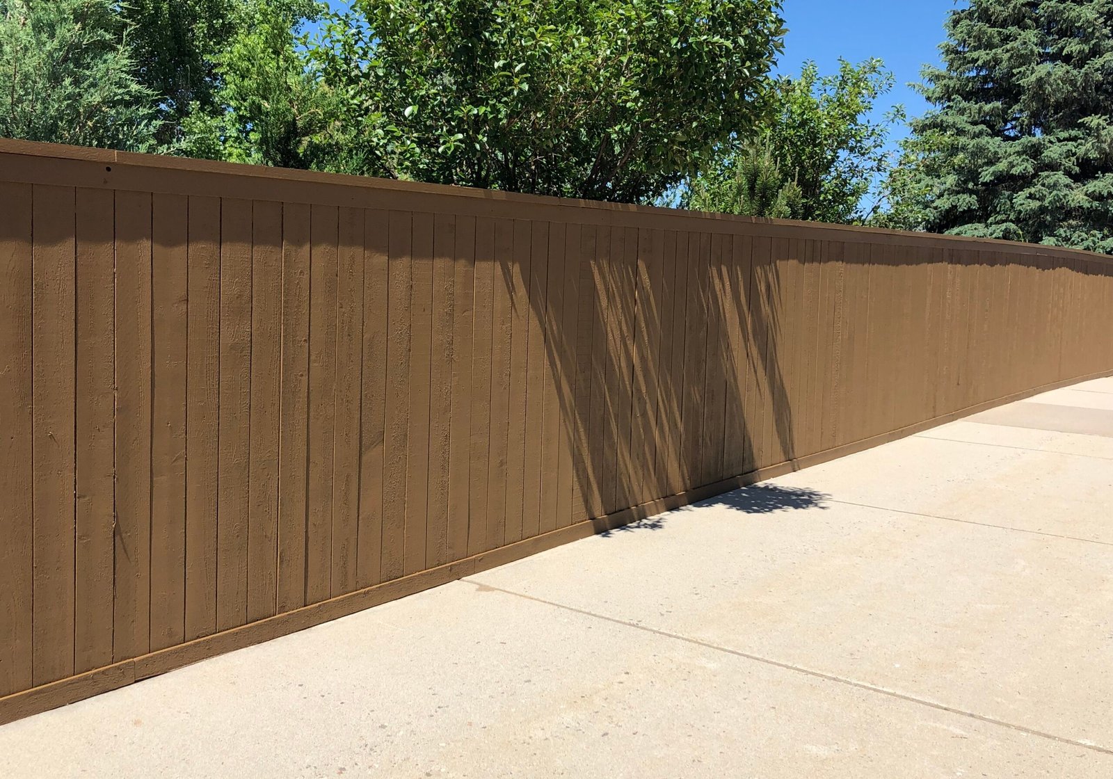 Commercial business fence that's stained by Paint EZ crew.