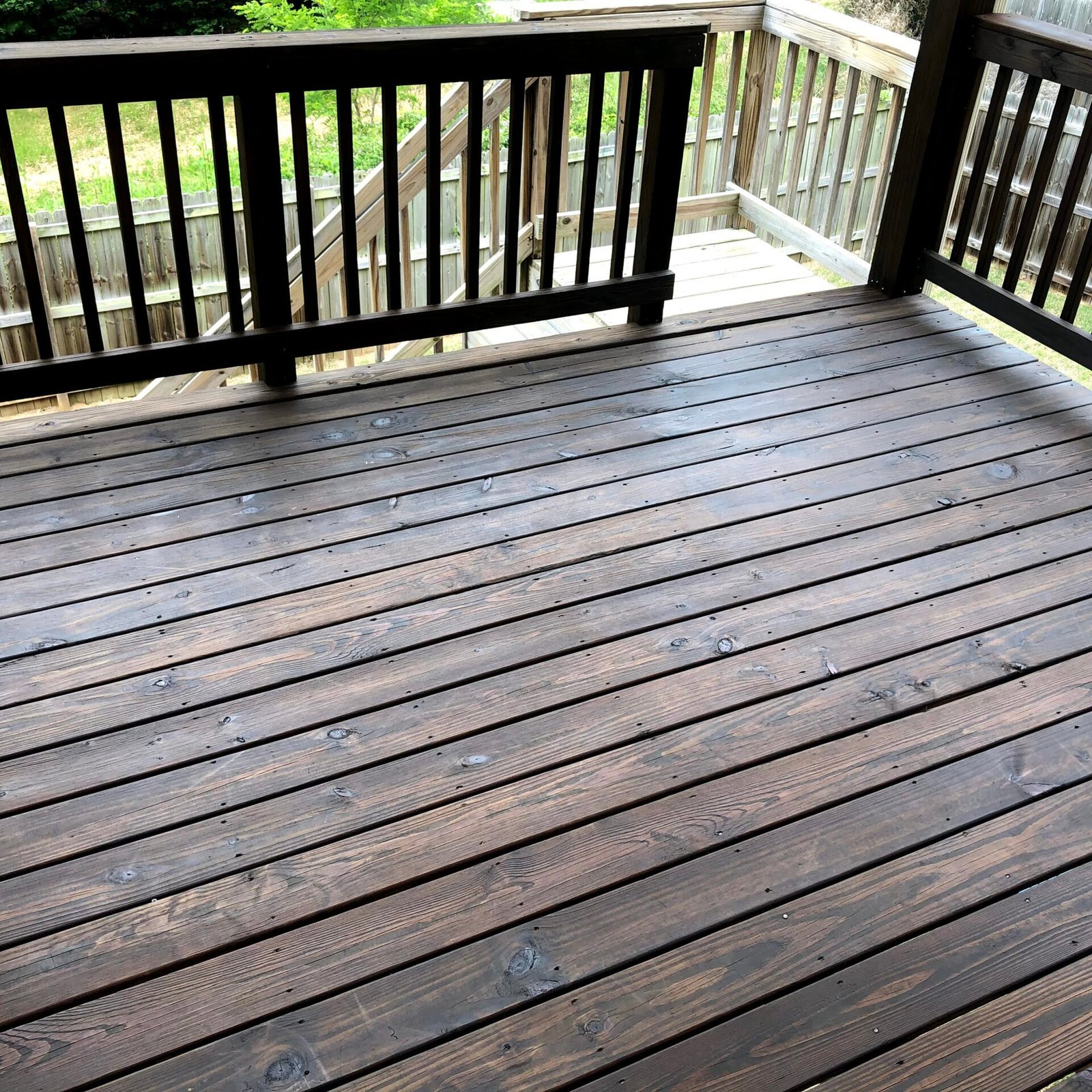 Freshly stained wooden deck by Paint EZ &ndash; professional deck and fence staining services that protect and enhance outdoor wood surfaces.