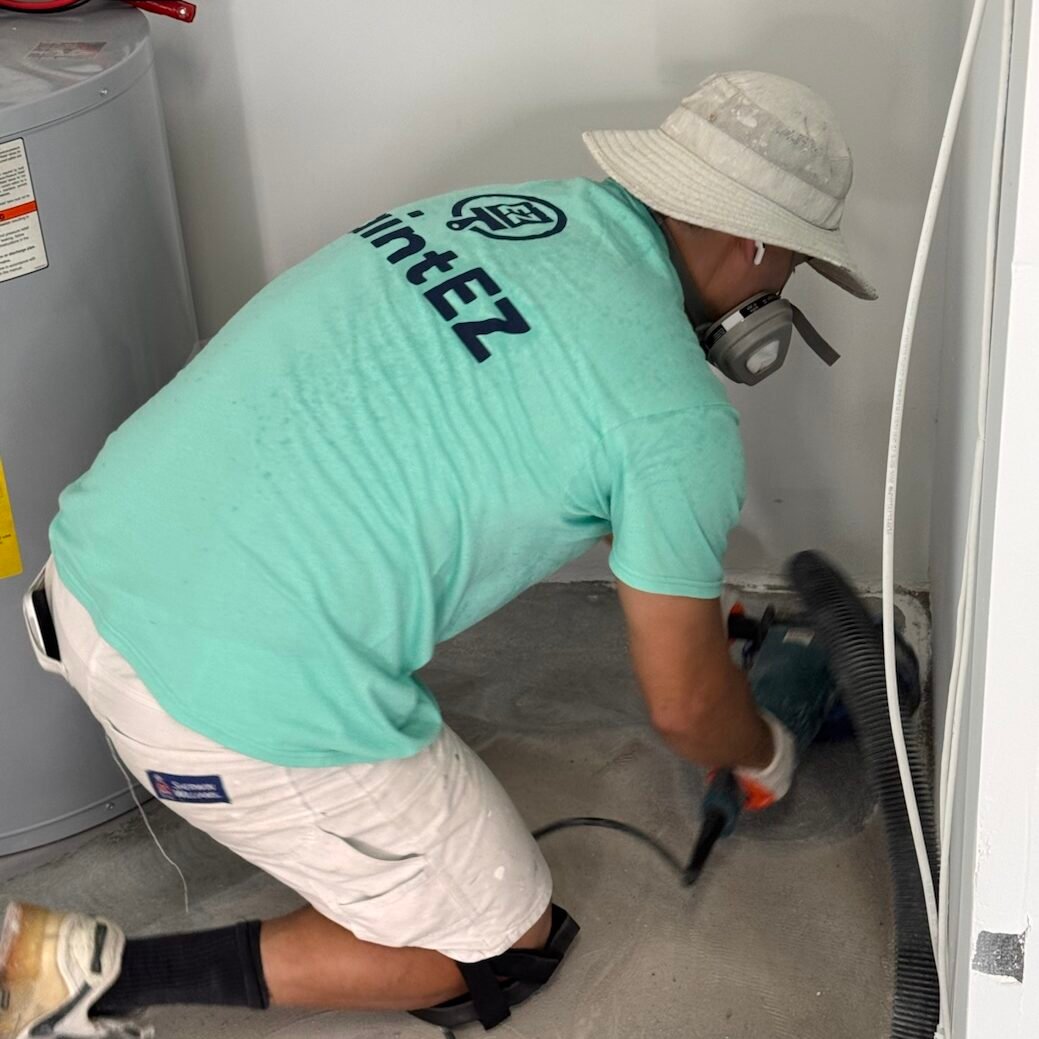 Paint EZ crew member preparing concrete for garage floor coatings