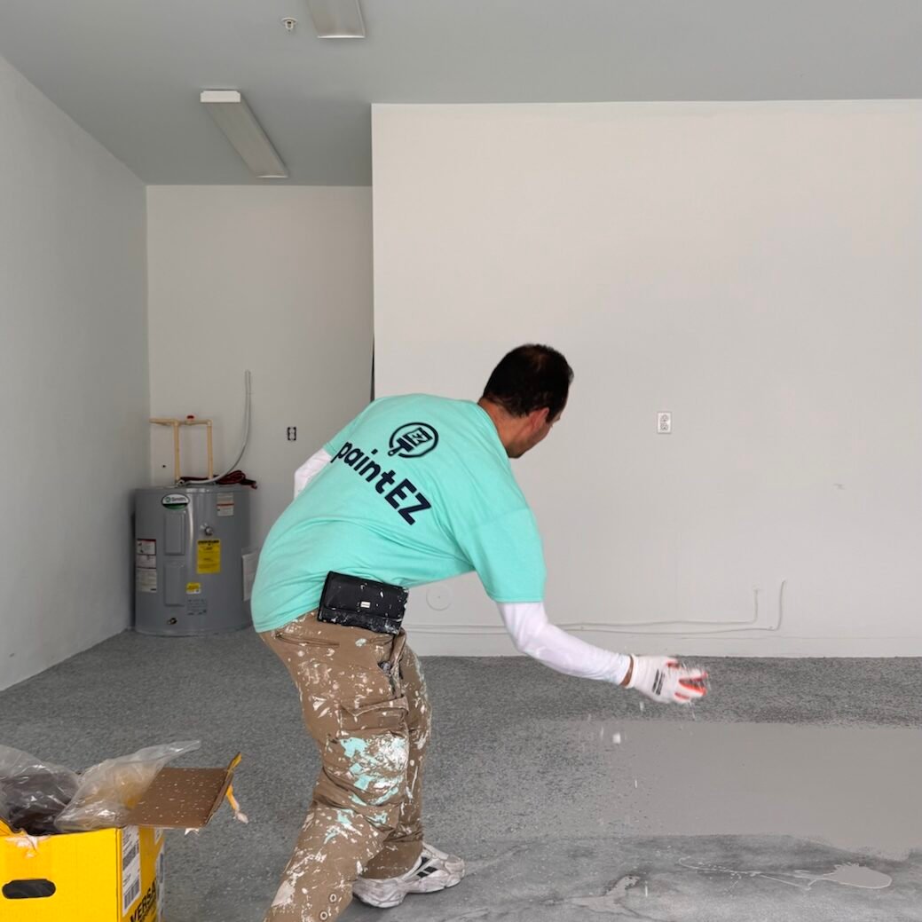 Paint EZ crew member adding flakes to garage floor coating.