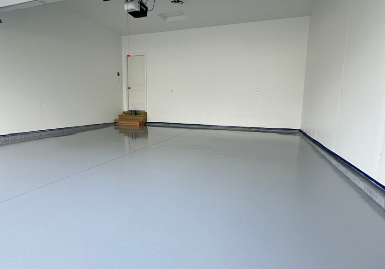 Professionally installed smooth gray garage floor coating in a residential garage.