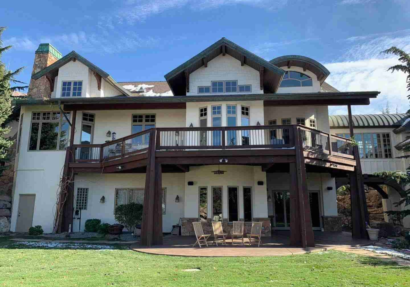 Exterior view of a two-story home in Salt Lake City with freshly painted trim and deck, completed by Paint EZ of Salt Lake City.