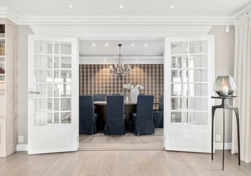 Dining room with plaid wallpaper accent wall professionally installed by Paint EZ, featuring seamless pattern alignment.