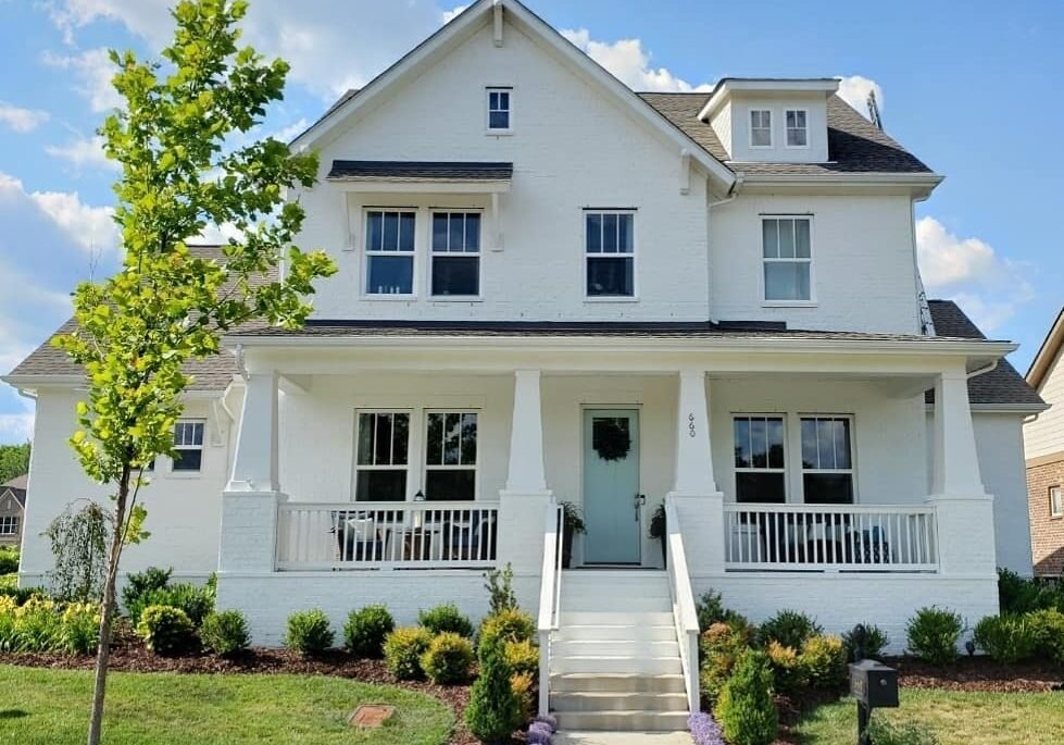 Brick home painted white with a light blue door.