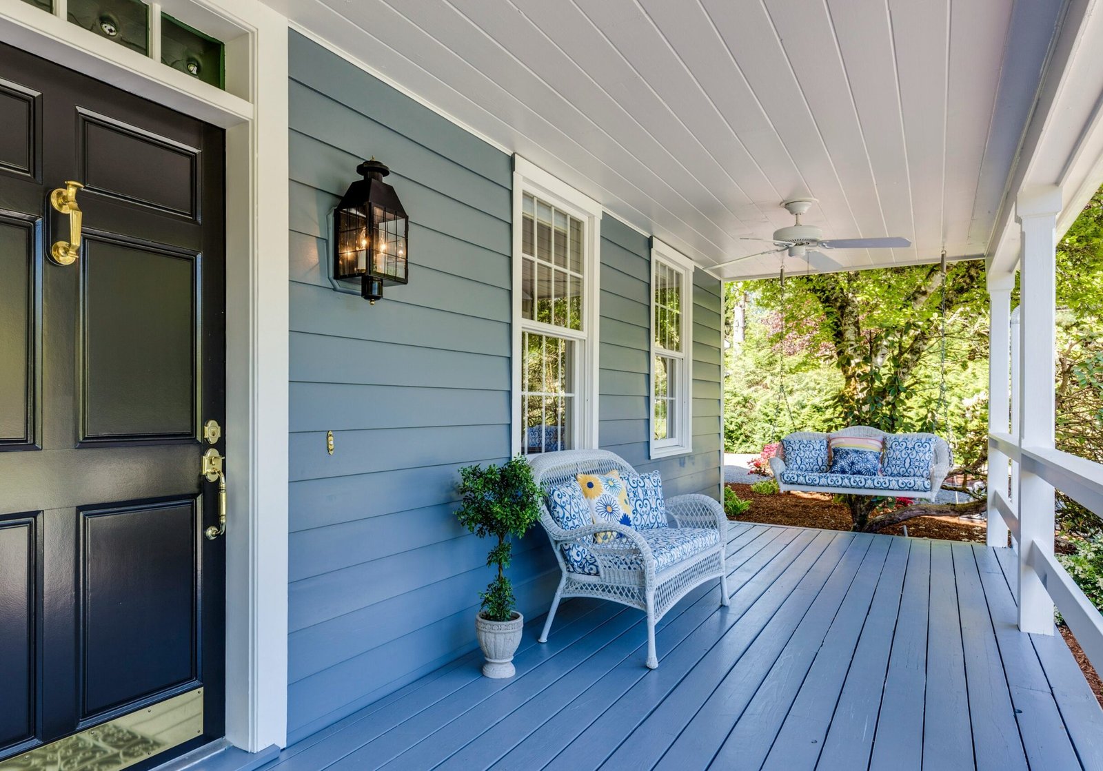 Welcoming front porch with coordinated neutral exterior paint and natural accents