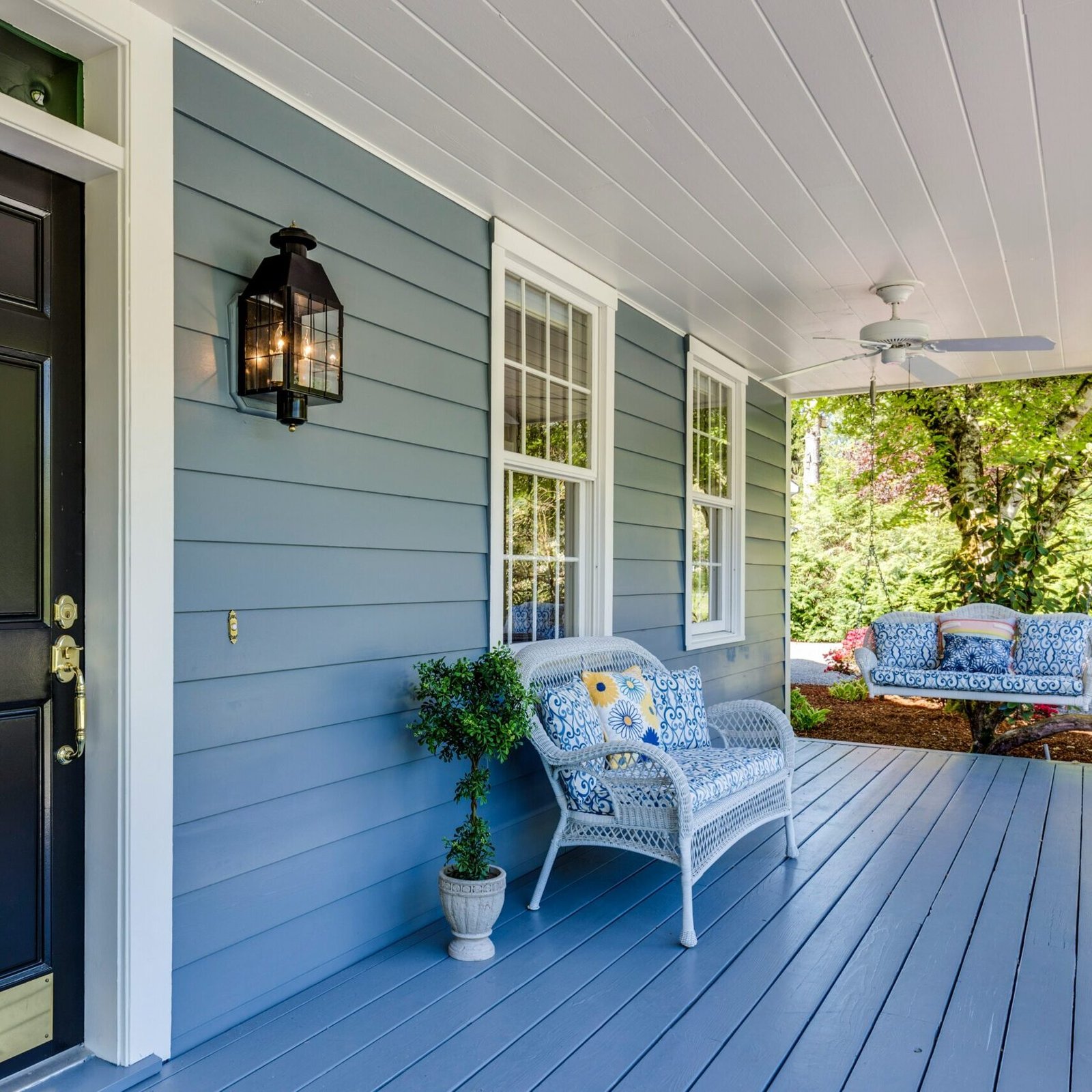 Welcoming front porch with coordinated neutral exterior paint and natural accents