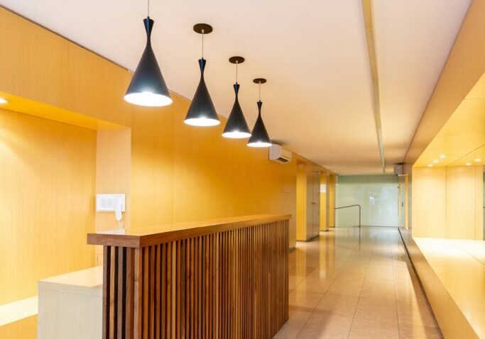 Professional commercial interior with freshly painted walls, modern lighting, and custom millwork in a contemporary office reception area.