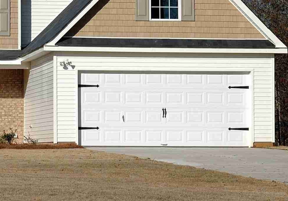 Paint EZ garage door painting project featuring a freshly painted white garage door on a tan & white exterior home with clean trim and updated curb appeal.