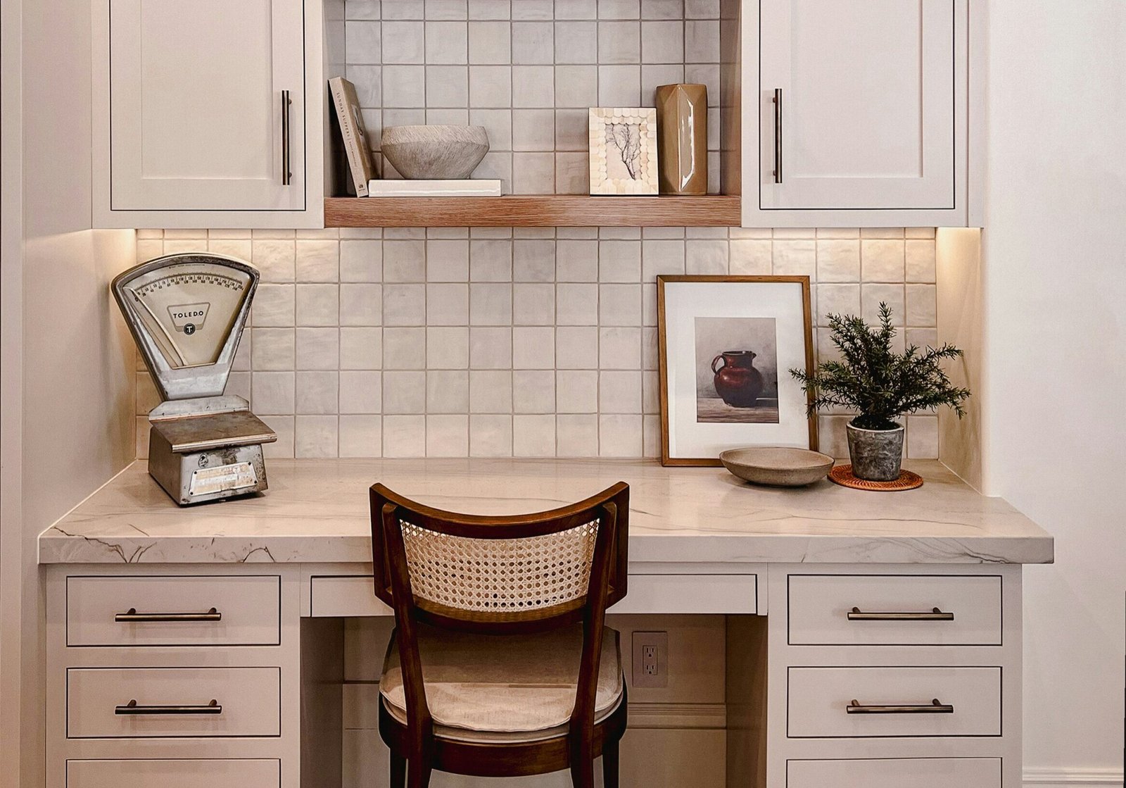 Home office nook with creamy white painted cabinets and warm wood shelving, capturing 2026 interior paint trends favoring soft whites and natural finishes.