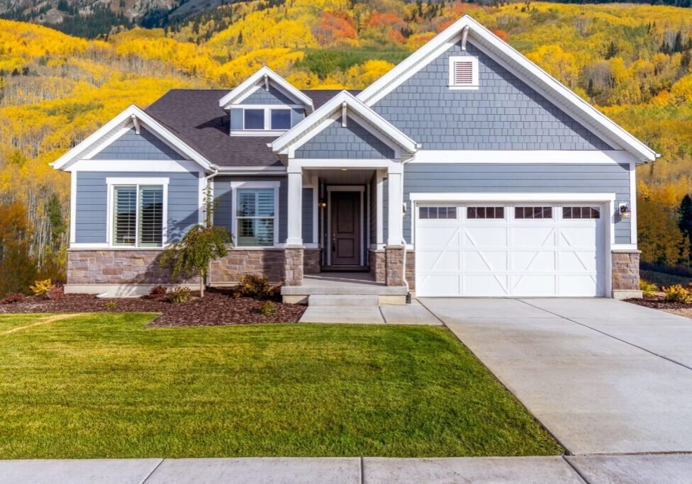 American suburban house surrounded by autumn trees during cool fall weather.