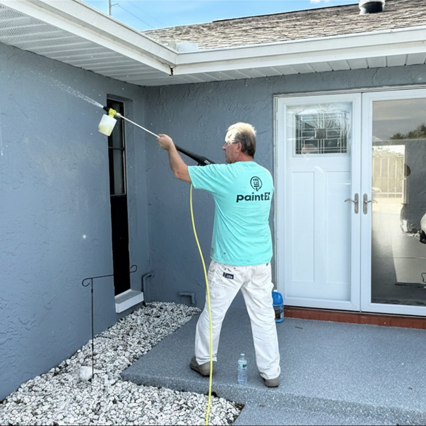 Paint EZ pressure washing outside of a home to prepare for exterior painting.
