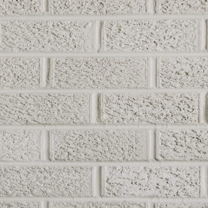 Close-up of white washed brick wall showing textured masonry surface and mortar joints