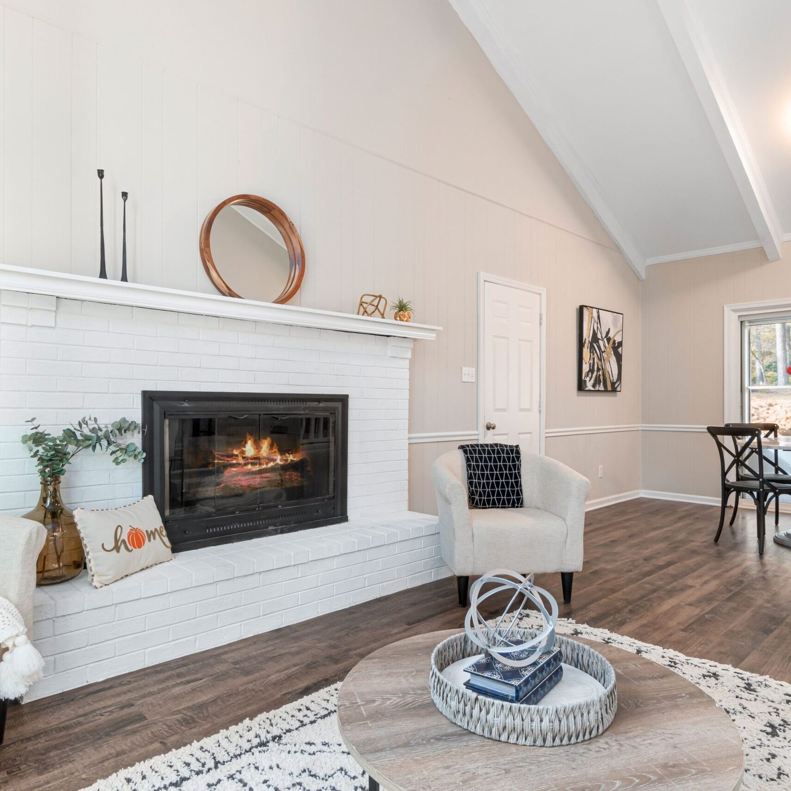 Modern living room featuring a white washed brick fireplace and neutral interior design